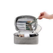 Astuccio da trucco grigio aperto con pennelli, cosmetici e scomparti organizzati. Ideale per viaggi, accessori bellezza, make-up.