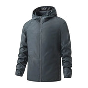 Giacca a vento impermeabile grigia con cappuccio, chiusura a zip, maniche lunghe, ideale per attività outdoor. Design moderno e funzionale.