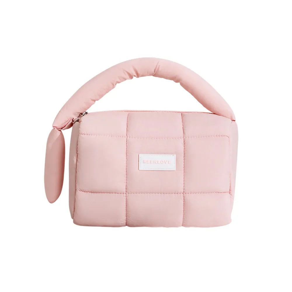 Borsa a mano trapuntata rosa, design moderno, manico imbottito, chiusura con zip, ideale per moda femminile e accessori eleganti.