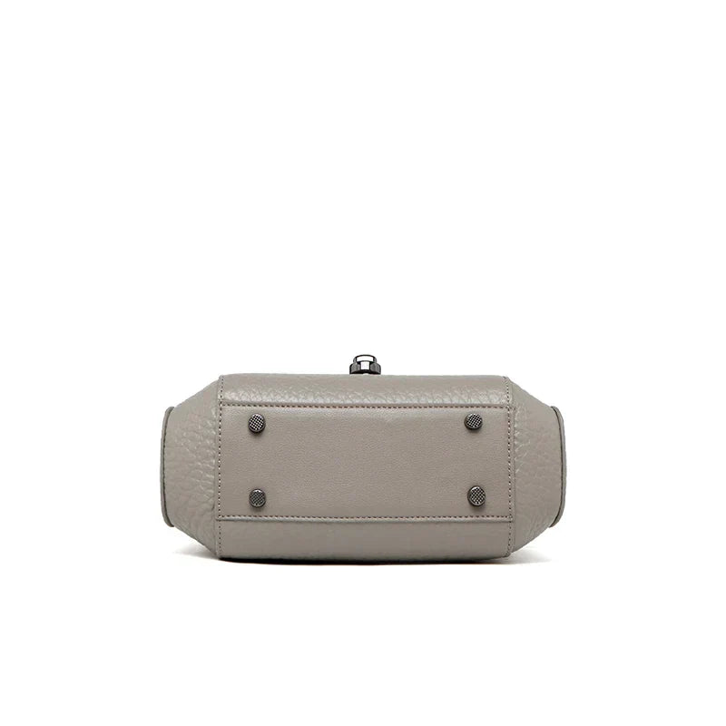 Borsa a tracolla in pelle grigia, vista dal basso, con piedini metallici. Design elegante e moderno, ideale per moda donna e accessori di lusso.