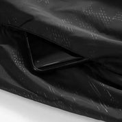 Giacca impermeabile nera con tasca nascosta, design moderno, tessuto resistente, ideale per smartphone, abbigliamento outdoor, moda funzionale.