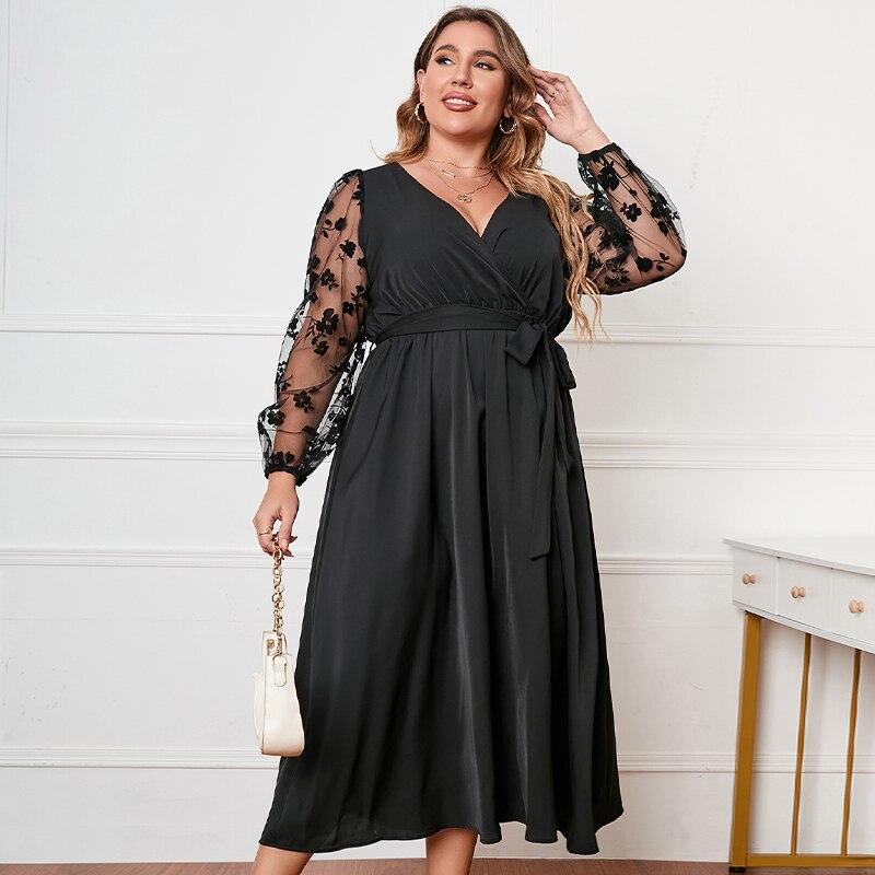 Abito nero elegante con maniche in tulle ricamato floreale, scollo a V, cintura in vita, perfetto per occasioni speciali. Moda donna taglie forti.