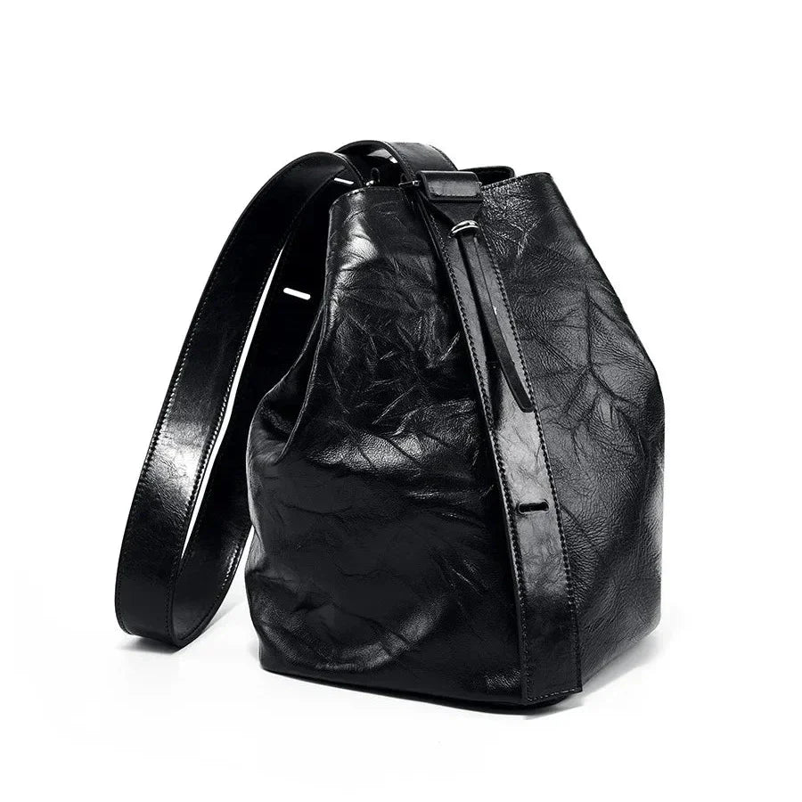 Zaino in pelle nera di design elegante, con chiusura a coulisse e spallacci regolabili. Accessorio moda unisex, ideale per ogni occasione.