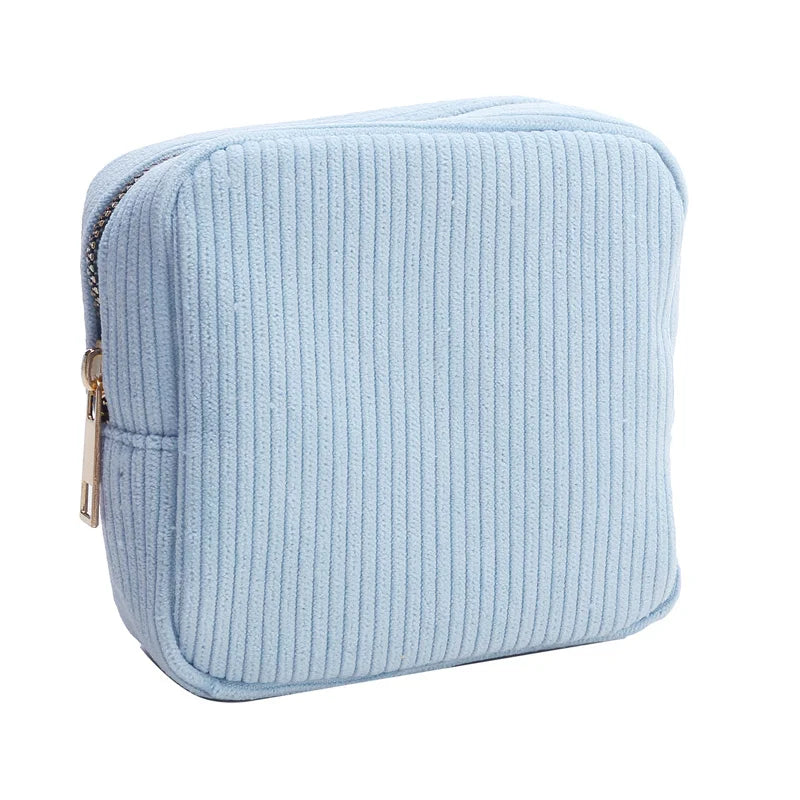 Astuccio quadrato in tessuto a coste azzurro con cerniera dorata, ideale per cosmetici o accessori. Design elegante e pratico per l'uso quotidiano.