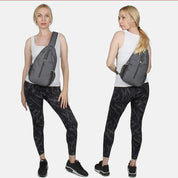 Donna con zaino monospalla grigio, indossa canotta bianca e leggings neri. Moda casual, abbigliamento sportivo femminile, accessori pratici.