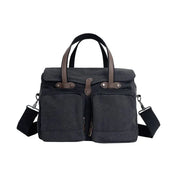 Borsa a tracolla in tela nera con manici marroni, doppie tasche frontali e tracolla regolabile. Design elegante e funzionale per uomo e donna.