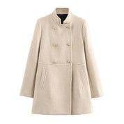 Cappotto beige donna, doppio petto, elegante, con bottoni dorati, tasche laterali, collo alto. Moda autunno inverno, abbigliamento femminile.