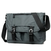 Borsa a tracolla grigia unisex, design moderno, con chiusure a fibbia e tasca frontale con zip. Ideale per lavoro e viaggio.