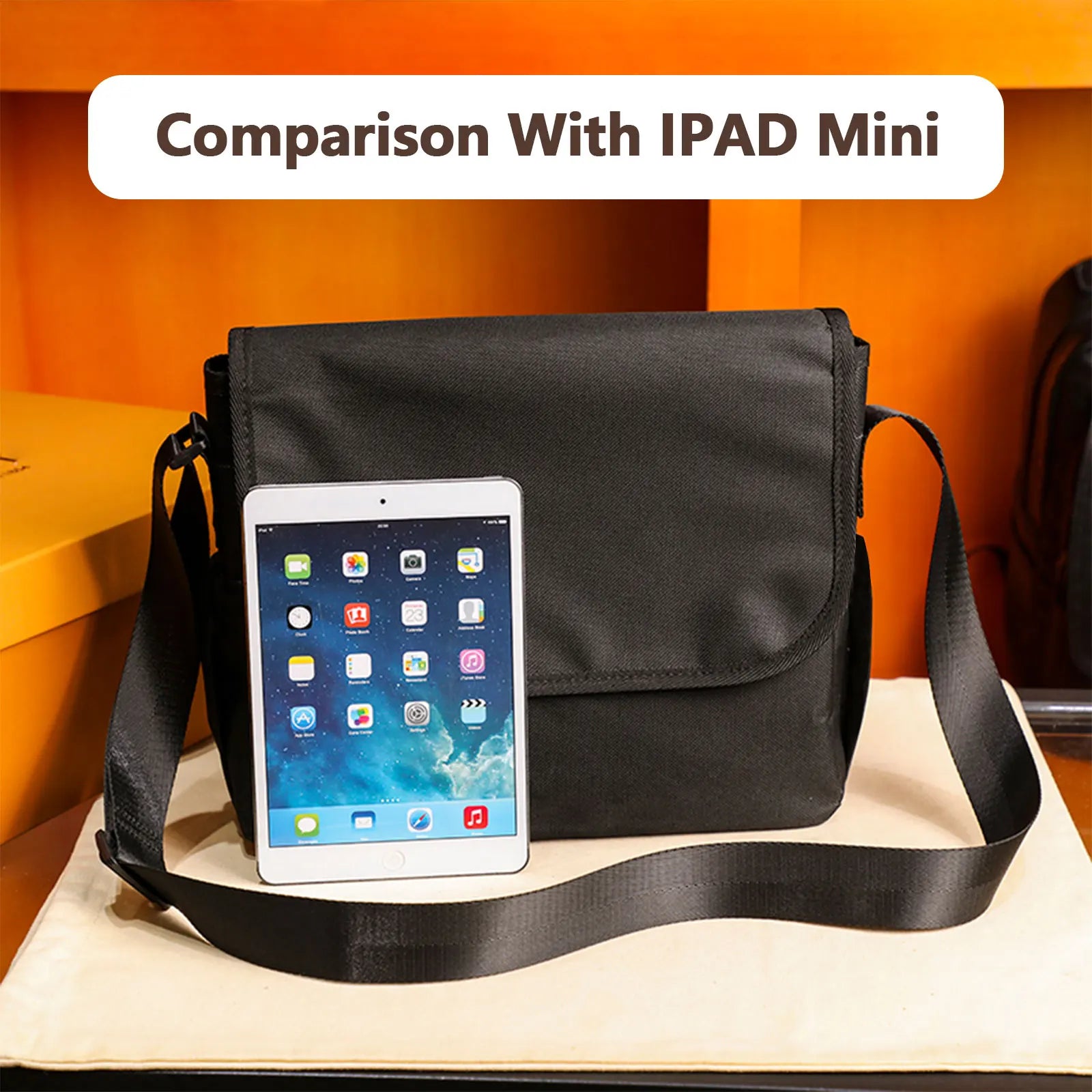 Borsa a tracolla nera con confronto dimensioni iPad Mini, design elegante, ideale per lavoro e viaggio. Tasche multiple, materiale resistente.