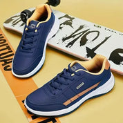 Scarpe da ginnastica blu con dettagli beige su skateboard, design moderno, suola bianca, perfette per sport e tempo libero.