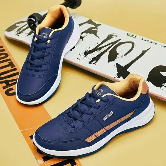 Scarpe da ginnastica blu con dettagli beige su skateboard, design moderno, suola bianca, perfette per sport e tempo libero.