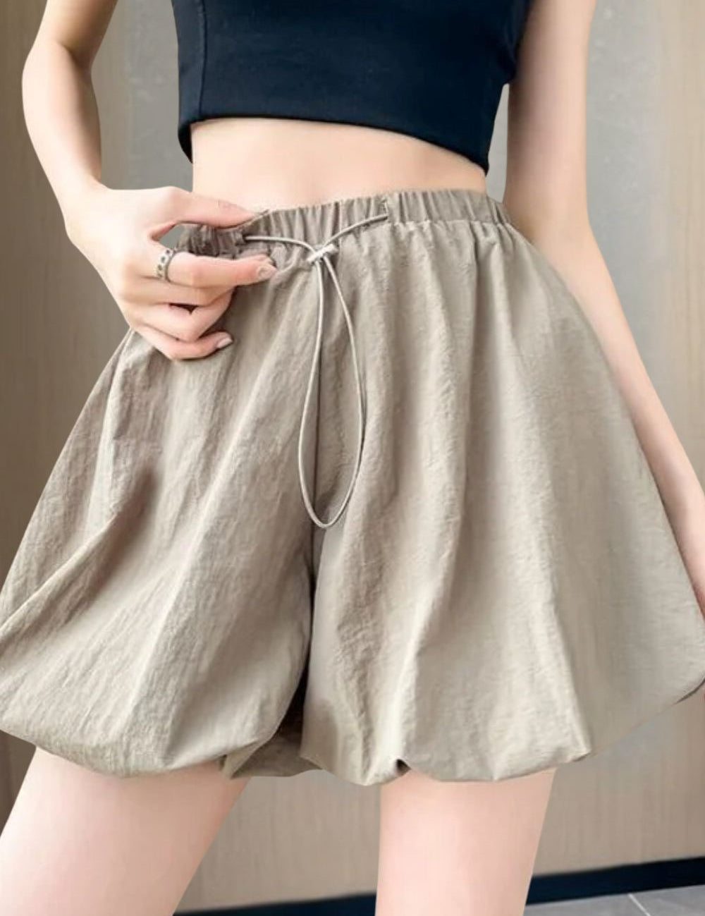 Shorts donna beige a vita alta, tessuto leggero, con elastico e laccio in vita. Abbigliamento estivo casual, moda femminile trendy.