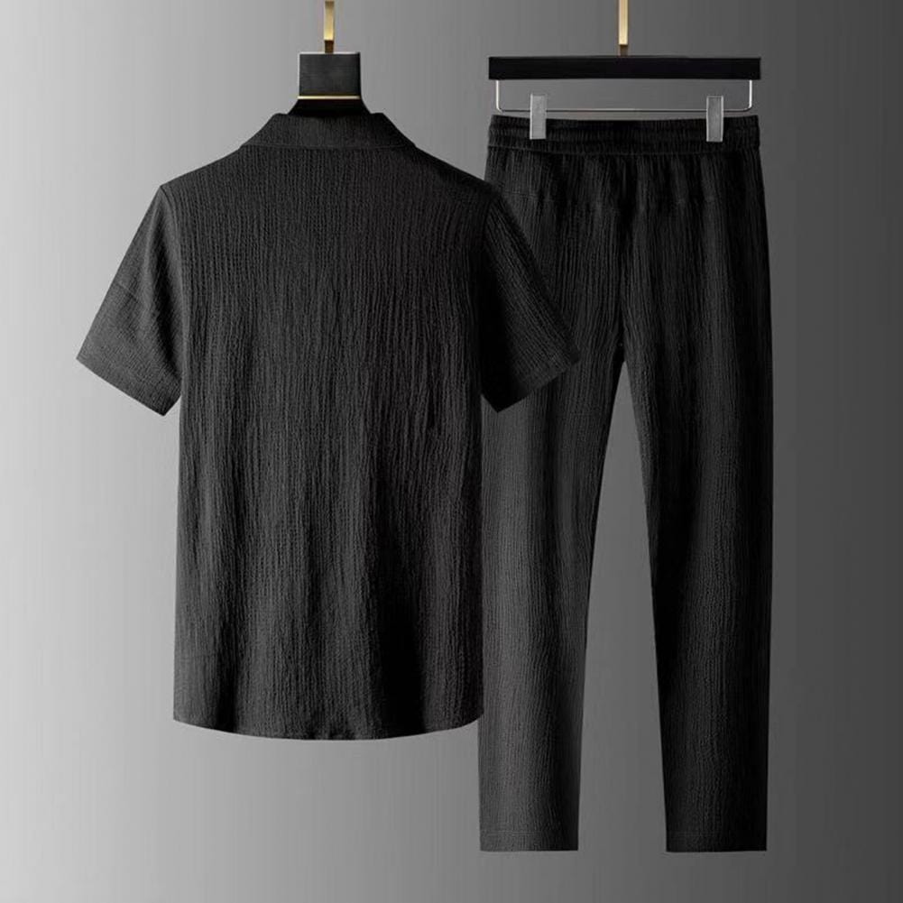 Completo uomo nero, camicia a maniche corte e pantaloni, tessuto leggero e strutturato, elegante e moderno, ideale per occasioni formali.