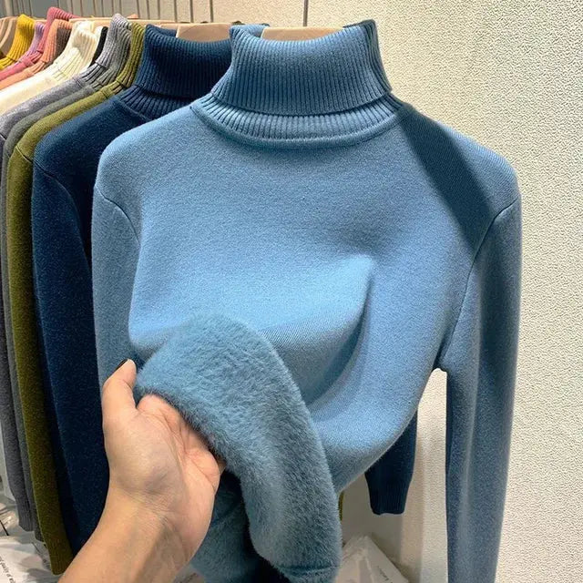 Maglione dolcevita azzurro in lana, morbido e caldo, esposto su appendiabiti. Ideale per moda invernale e abbigliamento casual elegante.