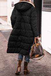 Donna con cappotto lungo nero imbottito, borsa in pelle marrone, stivali invernali, strada urbana. Moda invernale, abbigliamento caldo, stile casual.