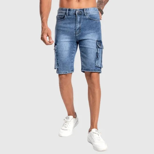 Shorts cargo uomo in denim blu, tasche laterali, vestibilità casual, perfetti per look estivi. Indossati con sneakers bianche.