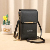 Borsa a tracolla nera in pelle PU con cerniera dorata, design compatto, accanto a vaso con cactus. Elegante accessorio moda donna.