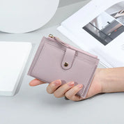 Portafoglio donna in pelle rosa chiaro con chiusura a bottone, design compatto, ideale per carte e contanti. Accessorio moda elegante e funzionale.