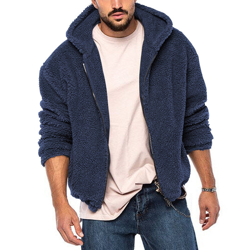 Giacca in pile blu da uomo con cappuccio, zip frontale, indossata su t-shirt beige e jeans. Moda casual invernale, abbigliamento caldo e confortevole.