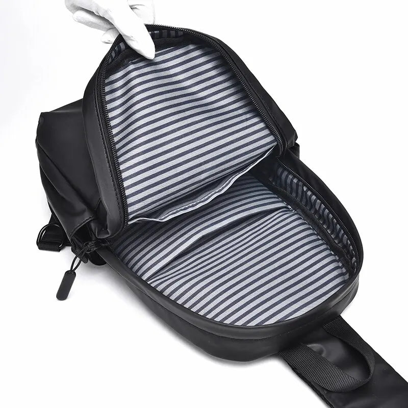 Zaino nero impermeabile aperto, interno a righe grigie e bianche, cerniera robusta, ideale per scuola e viaggio. Design moderno e funzionale.