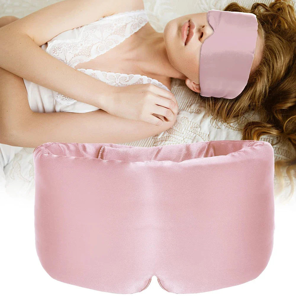 Donna che indossa maschera per dormire in seta rosa, rilassata su letto. Mascherina notte morbida, accessorio sonno, comfort, relax.