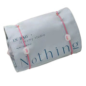 Borsa organizer da viaggio grigia con scritta "Nothing", chiusura con elastici rosa, design compatto, ideale per cosmetici e accessori.
