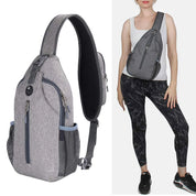 Zaino monospalla grigio unisex, design ergonomico, tasche multiple, indossato da donna in abbigliamento sportivo. Ideale per viaggi e attività all'aperto.