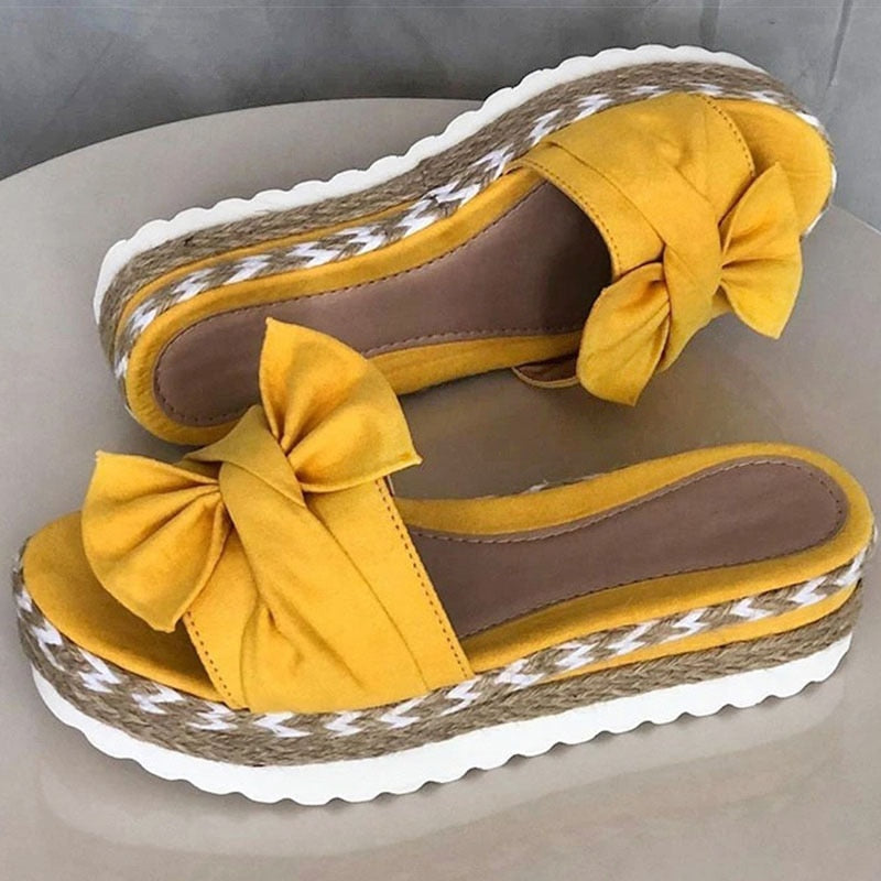 Sandali donna gialli con zeppa in corda intrecciata, fiocco decorativo, suola bianca ondulata. Scarpe estive eleganti e comode.