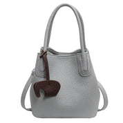 Borsa a mano in pelle grigia con ciondolo elefante marrone, design elegante, manici doppi, tracolla regolabile. Accessorio moda donna.