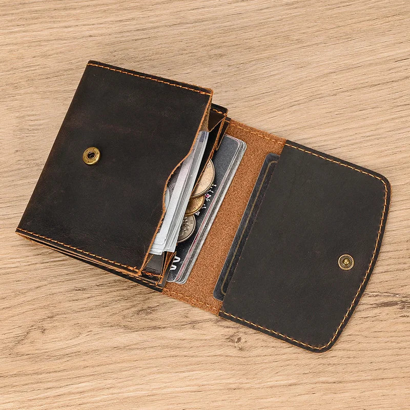 Portafoglio in pelle marrone aperto su tavolo di legno, con scomparti per carte di credito e monete. Accessorio elegante e funzionale per uomo e donna.