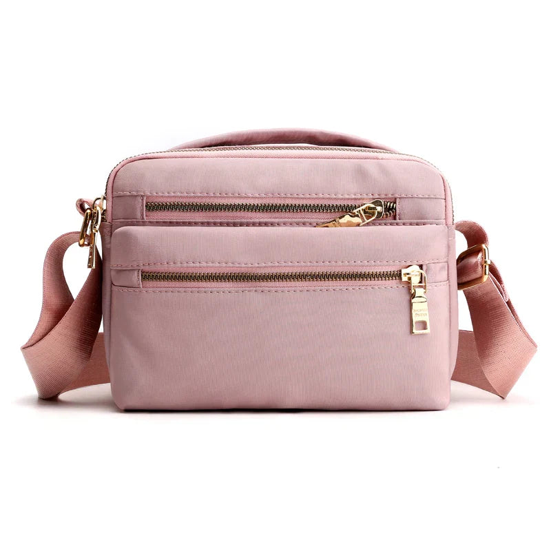 Borsa a tracolla rosa in nylon con doppia cerniera, tasche frontali, tracolla regolabile, design elegante e pratico per donna.