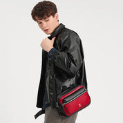 Giovane con giacca di pelle nera indossa borsa a tracolla rossa e nera. Moda uomo, accessori eleganti, stile casual.
