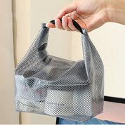 Borsa organizer in rete grigia trasparente, portatile, con manico, contenente prodotti cosmetici. Ideale per viaggi e organizzazione bagno.