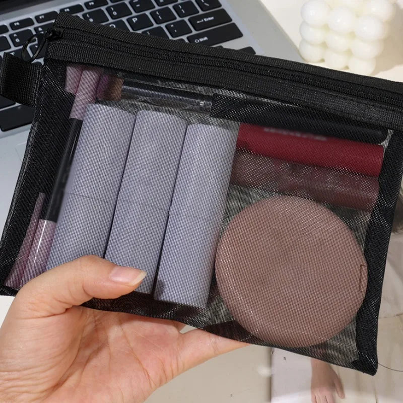 Borsa trasparente per cosmetici con rossetti, pennelli e cipria, ideale per organizzare il trucco. Accessorio da viaggio pratico e leggero.