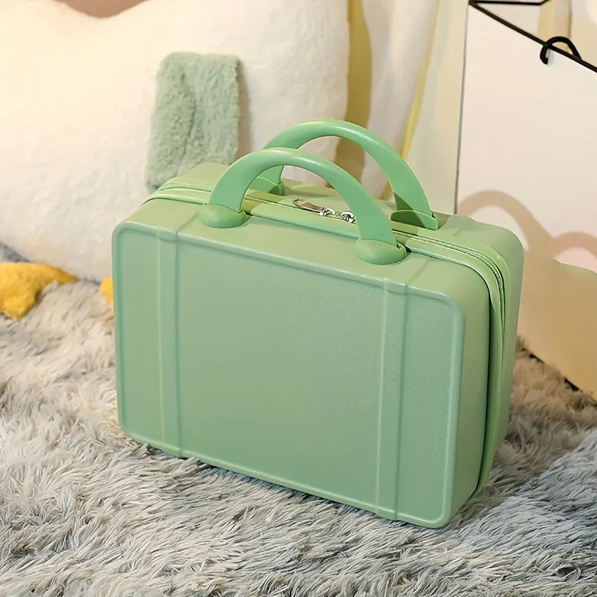 Valigia verde pastello su tappeto grigio, design compatto e moderno, ideale per viaggi brevi. Accessorio da viaggio elegante e funzionale.