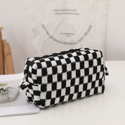 Astuccio a scacchi bianco e nero su tavolo, design moderno, ideale per cosmetici o accessori. Stile elegante e pratico per l'organizzazione quotidiana.
