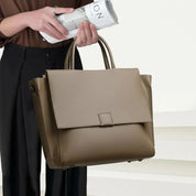 Borsa a mano elegante in pelle marrone, design moderno, chiusura a patta, ideale per lavoro e moda femminile. Accessorio di tendenza.