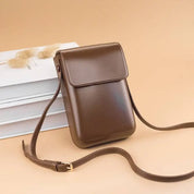 Borsa a tracolla in pelle marrone su sfondo beige, design elegante e minimalista, ideale per moda donna, accessori di tendenza, shopping online.
