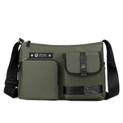 Borsa a tracolla verde militare con tasche multiple, chiusura a zip, dettagli in pelle nera, ideale per uomo, stile casual e urbano.