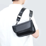 Borsa a tracolla in pelle nera, indossata da una persona con camicia bianca. Design elegante, ideale per moda uomo e accessori di lusso.