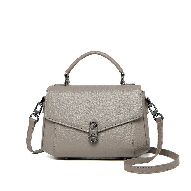 Borsa a tracolla in pelle grigia, design elegante con manico superiore e chiusura a scatto. Accessorio moda donna, stile casual chic.