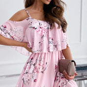Abito estivo rosa con stampa floreale, spalle scoperte, e borsa a mano beige. Elegante e femminile, perfetto per occasioni estive.