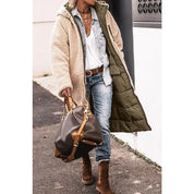 Cappotto lungo invernale beige, abbinato a camicia di jeans, jeans strappati e stivali marroni. Borsa a mano in pelle marrone. Moda casual donna.
