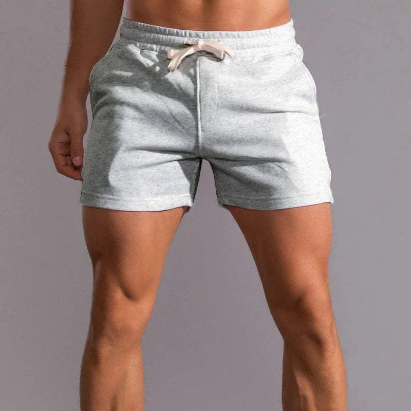 Shorts sportivi grigi da uomo, tessuto morbido, elastico in vita con laccio, ideali per palestra e fitness. Abbigliamento estivo casual.