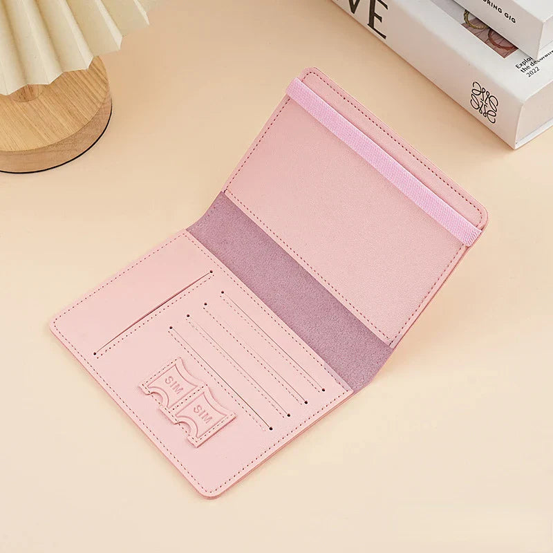 Portafoglio rosa in pelle sintetica aperto su tavolo, con scomparti per carte e banconote, design elegante e minimalista, accessorio moda donna.