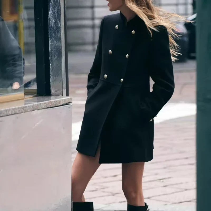 Cappotto nero elegante da donna con bottoni dorati, stile militare, indossato in città. Moda autunnale, abbigliamento femminile chic.