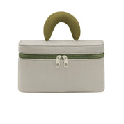 Borsa cosmetica beige con manico verde, chiusura a doppia zip, design elegante e compatto, ideale per viaggi e organizzazione trucco.