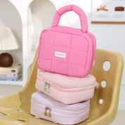 Borsa termica rosa su sedia gialla, design trapuntato, ideale per pranzo al sacco. Accessorio moda pratico e trendy per donne e ragazze.