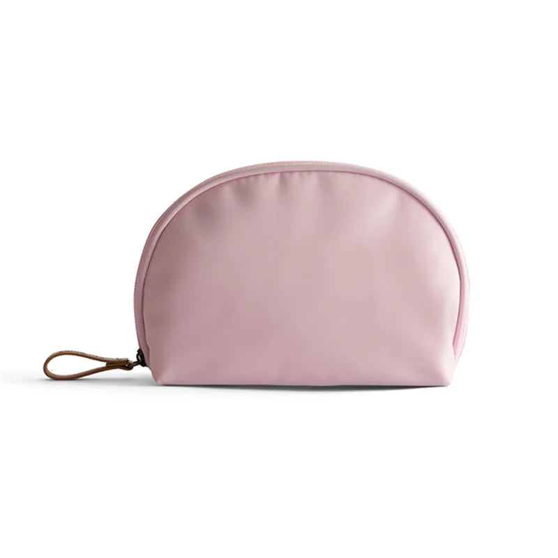 Astuccio cosmetico rosa chiaro in tessuto impermeabile, chiusura a zip, design elegante e compatto, ideale per viaggio e organizzazione trucco.