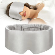 Maschera per dormire in seta grigia, donna addormentata, comfort e relax, accessorio per il sonno, blocco della luce, ideale per viaggi e riposo.